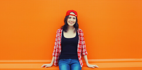 Summer portrait of happy smiling young woman posing in red baseball cap, casual clothes