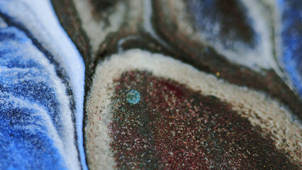 Paint spill. Glitter ink drip. Defocused blue red bronze white color shiny shimmering particles...