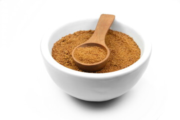 Coconut palm sugar in a white bowl with wooden spoon isolated on white. brown coconut palm sugar. 