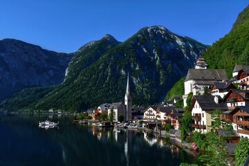 The lake and mountains in Austria in spring time and part of the settlement along the coast - obrazy, fototapety, plakaty