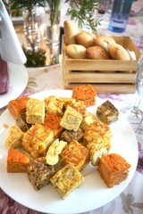Fresh bread rolls in a wooden basket with omelets dish