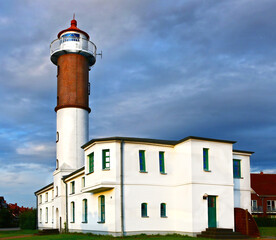 White building with a tower, green windows and pure blue than with the background