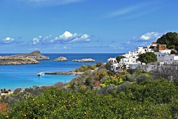 a view of the blue sea from a distance where you can also see part of the Greek settlement by the sea on a nice sunny day