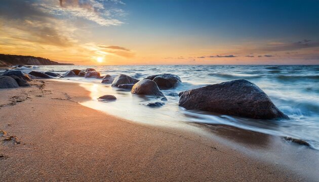 sand and rocks on seashore at sunset