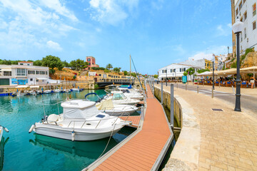 Boats line the picturesque marina port harbor full of shops and sidewalk cafes at the seaside town...