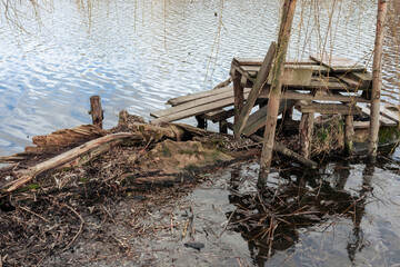 Ugly fishing platform. Handmade bench on the shore of the lake for fishing