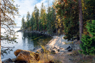 Autumn view of a small sandy beach and rocky cove on Tubbs Hill, a hiking trail loop along Lake...