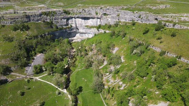 Drone footage shows green meadows and fields specific to Yorkshire in the Yorkshire Dales near Malham, Skipton, North Yorkshire UK