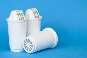  Three new filter cartridges for water purification on a blue background, close-up. Concept of...