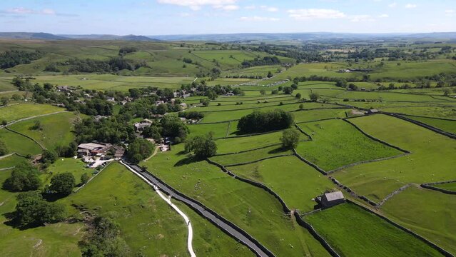 Drone footage shows green meadows and fields specific to Yorkshire in the Yorkshire Dales near Malham, Skipton, North Yorkshire UK