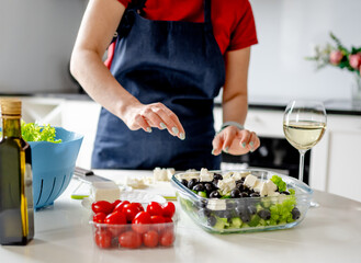 Housewife Puts Cheese In Bowl With Greek Salad Preparing Homemade Food - 755111074