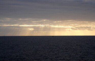 The sunrays through the clouds in the evening in Indian Ocean, Reunion island