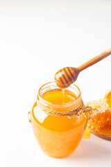 Honey dripping from a wooden honey dipper on white background. Healthy organic food concept. 