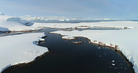 Fly above frozen panorama of Antarctic and old polar science wooden building. Antarctica majestic landscape drone view. Breathtaking harmony of untouched nature. Polar frozen ocean landscape