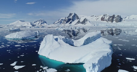 Close up polar seascape with iceberg at ocean bay aerial. Snow covered mountain at coast. Arctic...