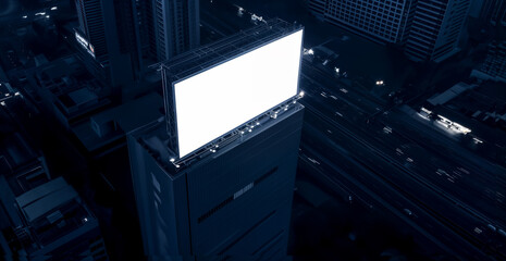 Blank white road billboard with cityscape background at night time. Street advertising poster, mock up