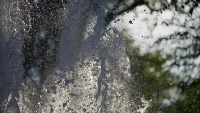 Magnified image of water fountain splashes, shimmering drops suspended in air.