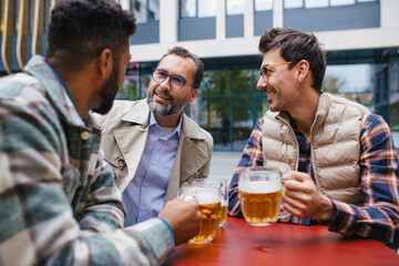 Best friends togehter, drinking beer and talking in bar in city. Concept of male friendship, bromance.