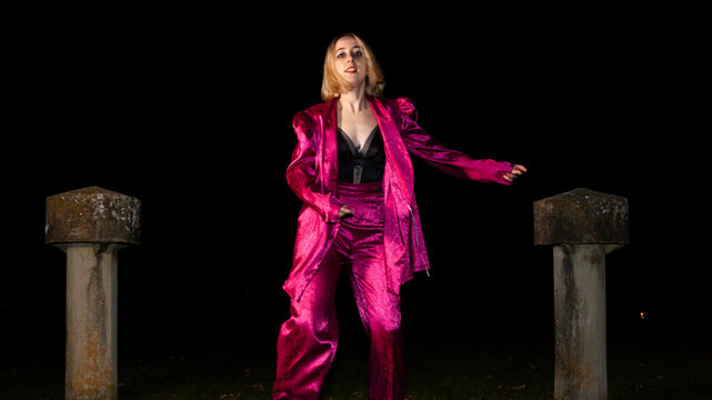 Energetic waacking dancer in shimmering pink at night