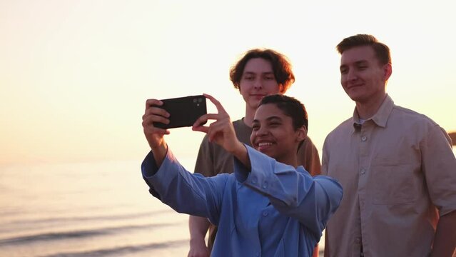 Cheers Funky mood. Happy friends group make selfie outdoor. Woman taking photo of friends on sunset. Group of young people taking photo on phone. Young girl mans enjoy their company smile have fun