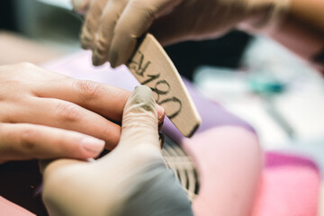 A beautician doing a manicure on a woman in her nail salon