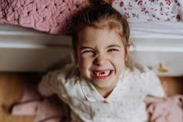 Portrait of cute girl smiling with gap-toothed grin, missing her baby teeth. - obrazy, fototapety, plakaty
