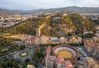 The drone aerial view of Malaga Bull ring and Gibralfaro hill at sunrise, Spain. 