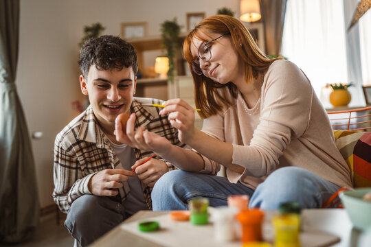 young man and woman couple or brother and sister paint easter eggs