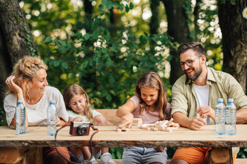 Family spending time in nature and playing with wood block puzzle.