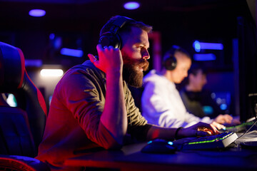 Worried bearded man gamer playing PC video game on a cybersport tournament