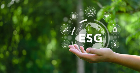 ESG. Word ESG in hand. Concept for environment, society and governance. with icons around it On...