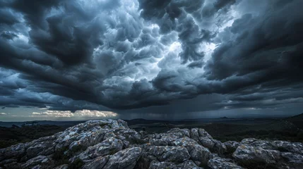 Foto op Canvas A dramatic sky with dark, rolling clouds over a rocky landscape, creating a mood of impending storm. © furyon