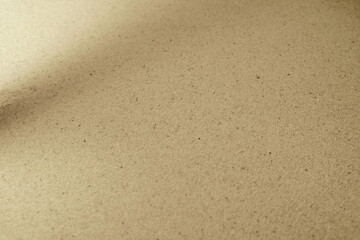 Shadows and patterns on the sand of dune. Sandy beach for the background. Sand texture. Background, sand, light, beige, wave, reflect, shadow, summer. Summer concept.