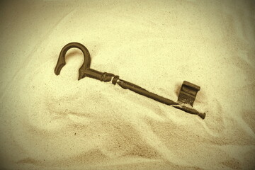 Unlock your future. Old vintage key on the sand. Forgotten, unwanted, old, antique, key in a sand...