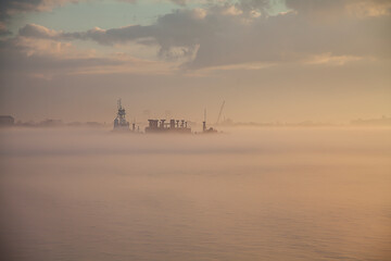 Barge in the Fog.  Riverfront Park New Orleans LA.   A serene seascape is enveloped in a thick...