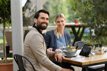 Business lunch for two managers, discussing new business project. Couple sitting outdoors on terrace restaurant, having dinner date. - 755175001