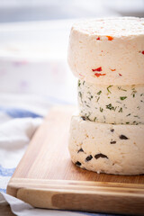 Several varieties of homemade cheese with different fillings with paprika, dill and olives on a wooden board - 755175690