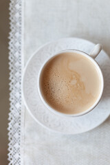 Top view of a tablecloth covered with a cup of delicious morning coffee. - 755176281