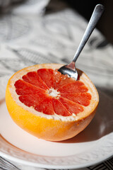 Half of fresh grapefruit on a plate with a spoon. Healthy lifestyle. Directly Above - 755176414