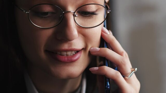 Closeup face woman calling by smartphone . Serious attractive businesswoman talking emotionally at mobile phone. Happy and calm lady boss complaining at telephone conversation