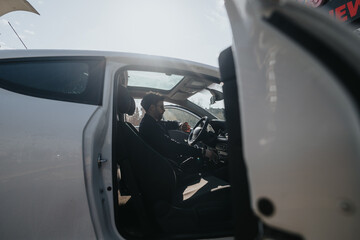 Side view of a concentrated man driving a car through the city on a sunny day, emphasizing urban mobility and daily commute.