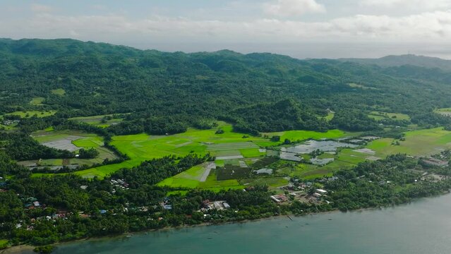 Sun reflection over blue sea and Island with paddy farmland. Looc, Tablas Island. Romblon, Philippines.