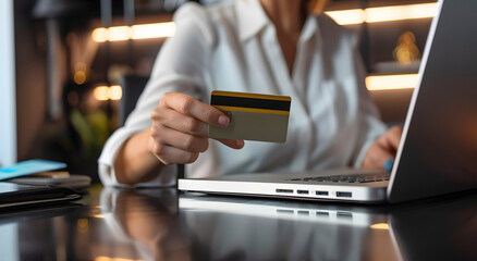 women holding a credit card in her hand while shopping online on a laptop