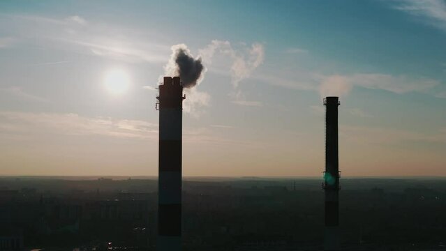Kominy przemysłowe na tle zachodzącego słońca