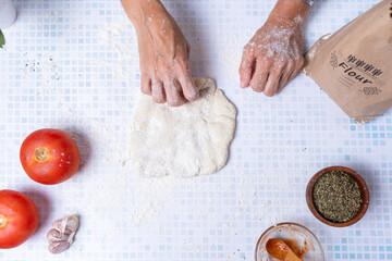Woman's hands stretching a flour dough.