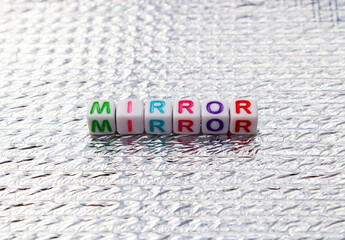 Mirror word composed with cubes on silver background