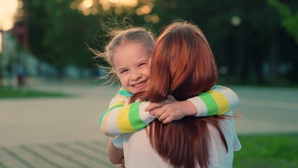 Child, daughter runs to mom hugs her in park on street in autumn. Happy family. Carefree childhood,...