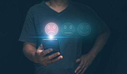 Customer experience dissatisfied concept, Businessman holding smartphone with sadness emotion face on screen, unhappy, Bad review, Low rating, Dissatisfied with products and services. - obrazy, fototapety, plakaty