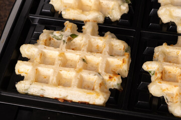 Waffle maker with dough in the process of making waffles