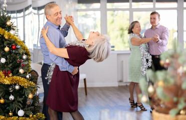 Couple of elderly man and elderly woman dancing waltz in studio